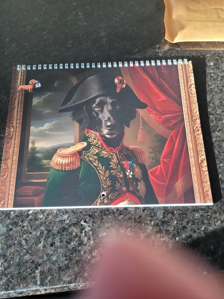 Un calendrier imprimé représentant un chien vêtu d’un uniforme militaire repose sur un comptoir foncé.