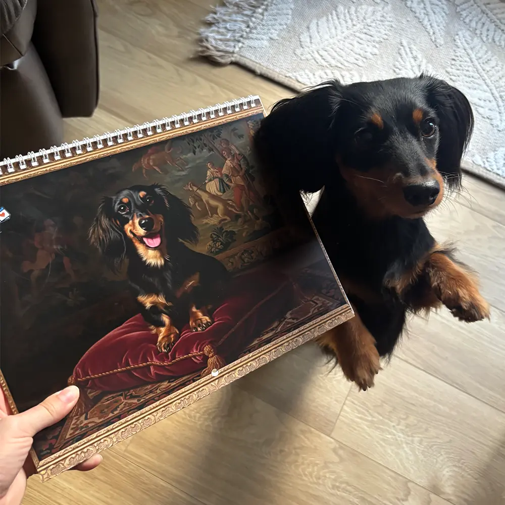 Une personne tient un calendrier Renaissance imprimé à côté d’un chien noir et feu debout sur ses pattes arrière.